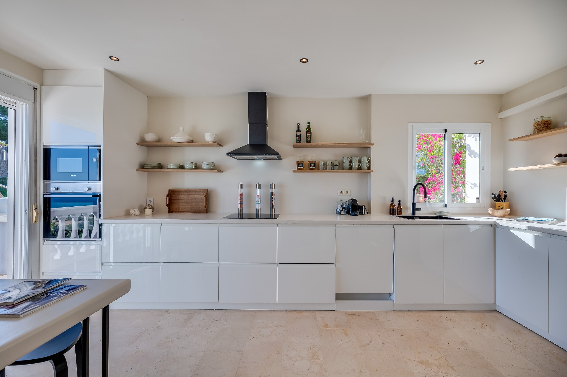 Ruime keuken met hoogglans witte kasten en open eikenhouten planken