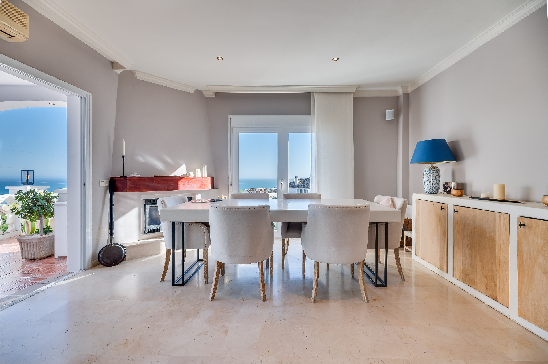 Eetkamer met open haard, grote tafel en uitzicht richting terras