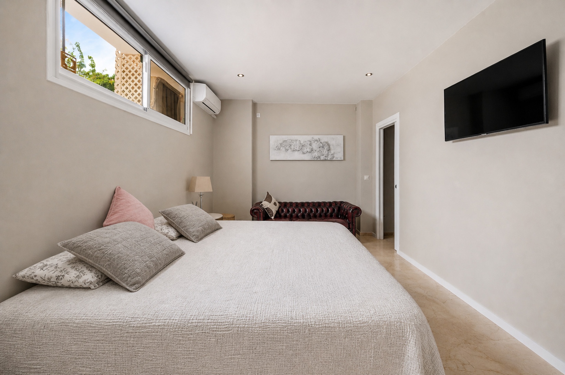 Ruime slaapkamer 5 met tv, chesterfield en lichte tinten