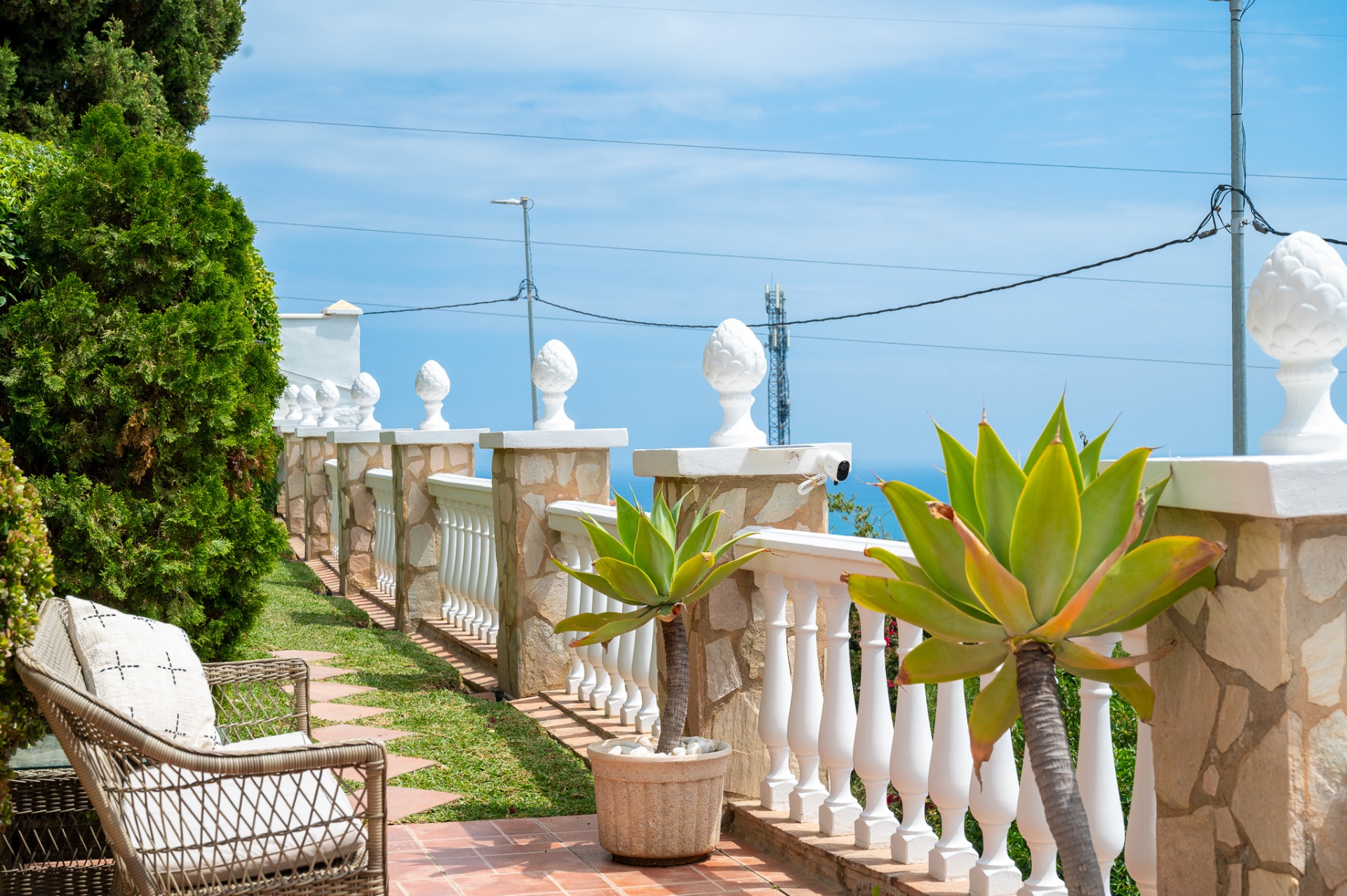 Witte balustrade met agaves en zicht op de Middellandse Zee